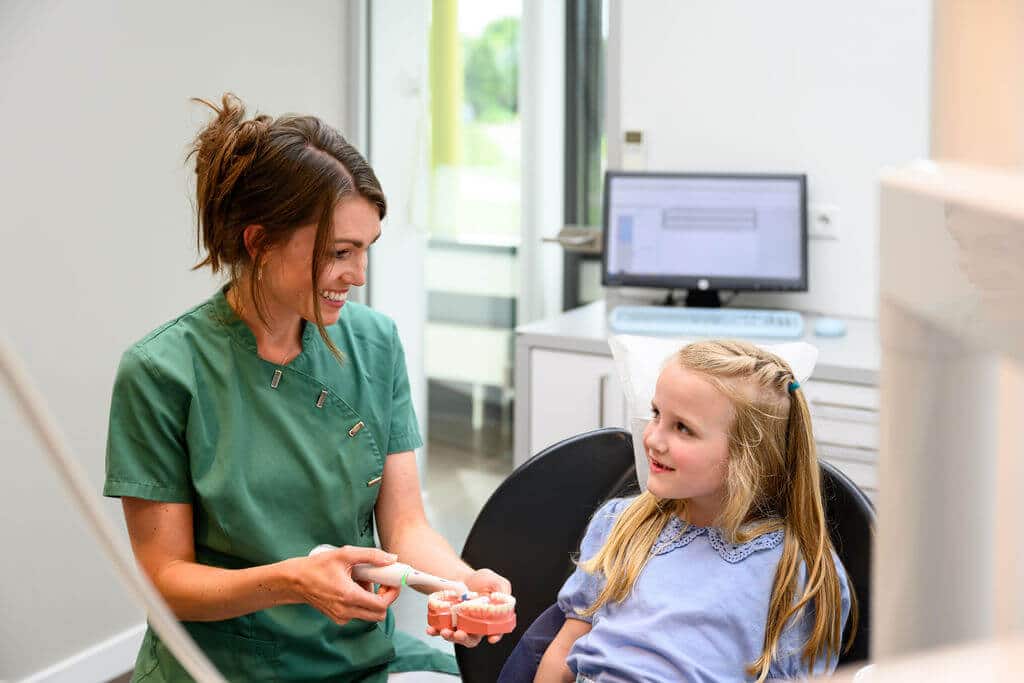 Mondhygiënist bij Kies & Co IJsselstein instrueert patiënt over de juiste techniek voor flossen en reinigen tussen de tanden met ragers